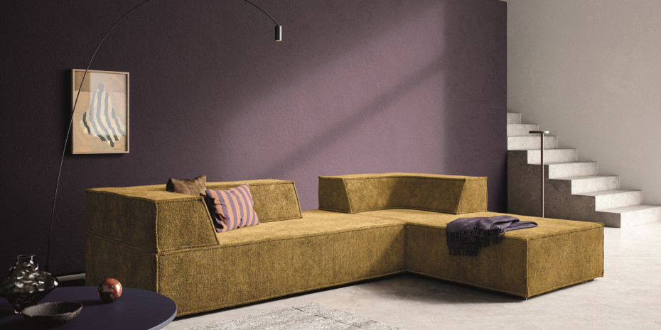 Weich und flauschig: Der hochflorige Chenille-Bezug in kräftigem Messinggelb verleiht dem Polsterklassiker einen ganz besonderen Charakter, an der Wand die Modefarbe Lila.&nbsp;