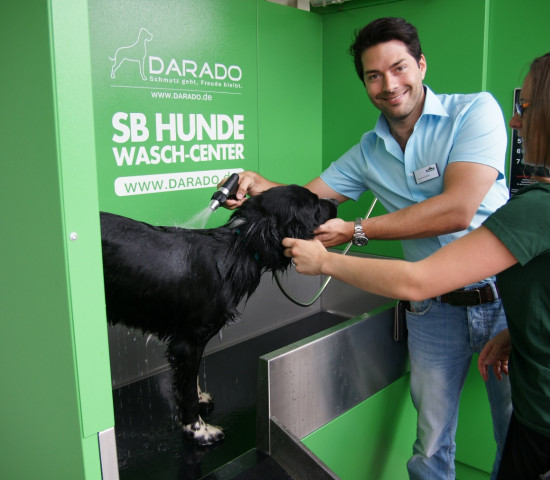 Dehner-Marktleiter Johannes Spahn testet gemeinsam mit einer Mitarbeiterin das Hunde-Wasch-Center in Karlsruhe. Foto: Darado