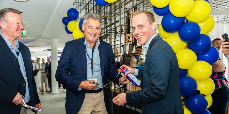 Steve Brass (v.l.), Chairman Eric P. Etchart und Daniel Kalisch durchschnitten feierlich das Band – als Schmiermittel für die Schere diente das hauseigene Multifunktionsprodukt.&nbsp;