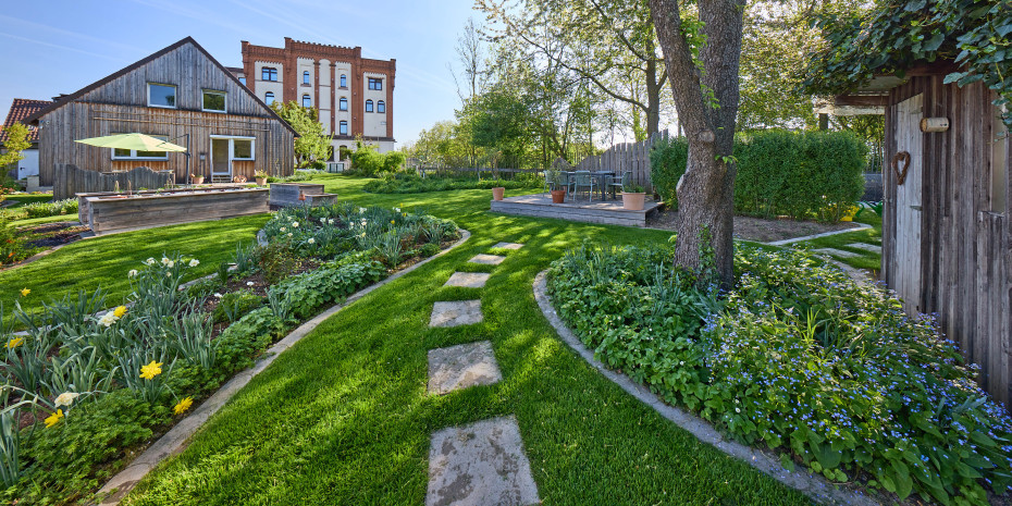 Blick aus dem Firmengarten: Der Hauptsitz von Neudorff wird von einer Photovoltaikanlage und einer Wasserturbine mit Strom versorgt.